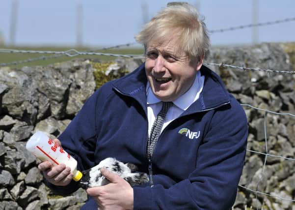Boris Johnson during a recent farm visit as his commitment towards farmers comes under scrutiny.