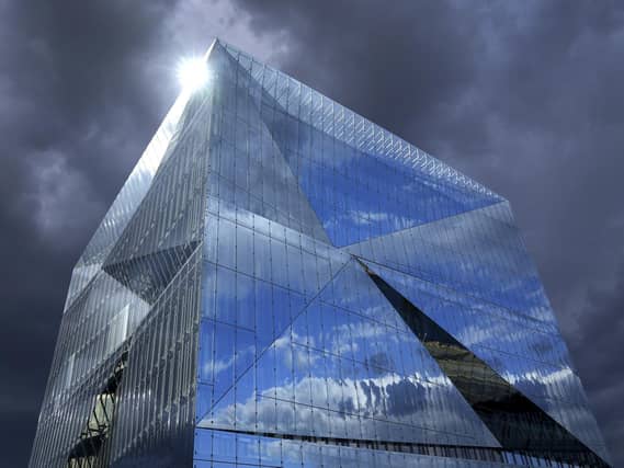 Dark clouds are seen as the sun is reflected in the glass surface of the "Cube Berlin" office building. PIC: PA