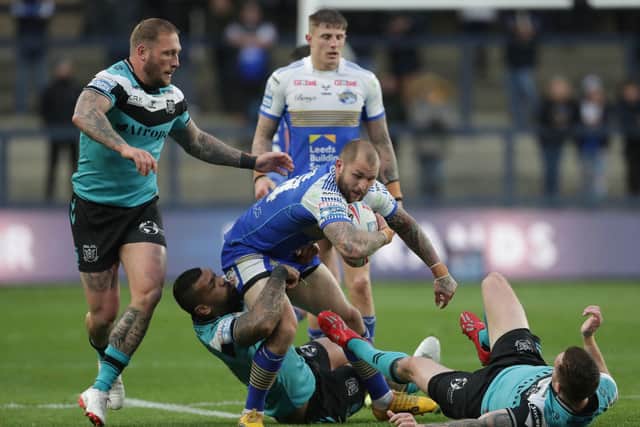 Snared: Leeds Rhinos' Luke Briscoe (centre) tries to force his way through the Hull cover. Picture: Richard Sellers/PA Wire.
