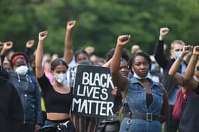 Protesters hold up fists at a gathering in support of the Black Lives Matter movement on Woodhouse Moor in Leeds in northern England on June 21, 2020, in the aftermath of the death of unarmed black man George Floyd in police custody in the US. (Photo by Oli SCARFF / AFP)