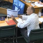 Dominic Cummings, former Chief Adviser to Prime Minister Boris Johnson, holds up a document whilst giving evidence to a joint inquiry of the Commons Health and Social Care and Science and Technology Committees on the subject of Coronavirus: lessons learnt. Pic: PA