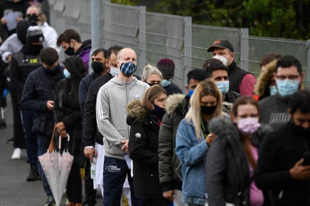 Members of the public queue to receive a Covid-19 vaccine at a temporary vaccination centre at the Essa academy in Bolton on May 17, 2021. (Photo by OLI SCARFF/AFP via Getty Images)