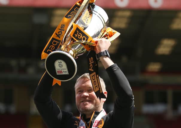 Champion: Hull City manager Grant McCann celebrates with the League One trophy.