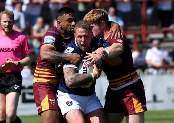 Wakefield player Joe Westerman is held up by the Huddersfield defence. Pictures:  Simon Hulme