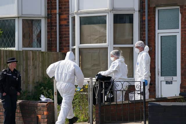 Police forensic officers work at the scene in High Holme Road, Louth, Lincolnshire, following the death of a woman and child on Monday.