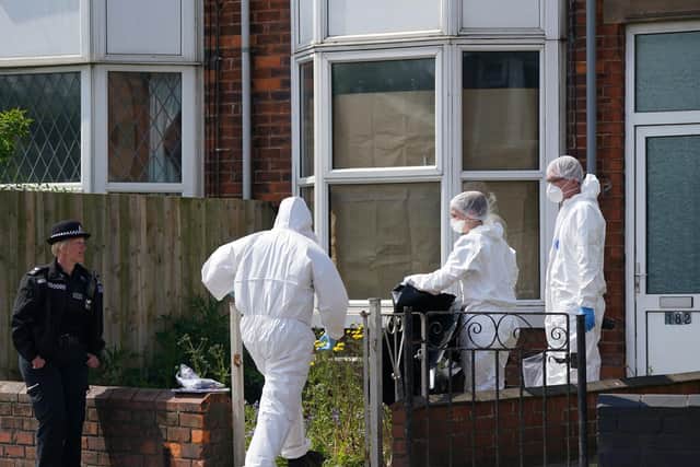 Police forensic officers work at the scene in High Holme Road, Louth, Lincolnshire, following the death of a woman and child on Monday. An urgent appeal has been issued by police to find Daniel Boulton, 29, in connection with the incident.