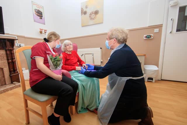 Mike Padgham (right) visits his 93-year-old mother Phyllis Padgham (centre) with Activities Assistant Charlotte Henderson (left) at St Cecilia's Nursing Home in Scarborough, North Yorkshire.