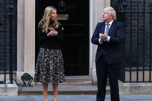 Boris Johnson  and his then fiancee Carrie Symonds participate in a national "clap for carers" celebration last year at the start of the pandemic.