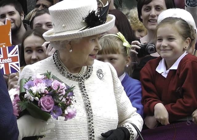The Queen is greeted by flag-waving well-wishers as she visits the City Varieties Music Hall in Leeds on July 19, 2012 during her diamond jubilee tour.