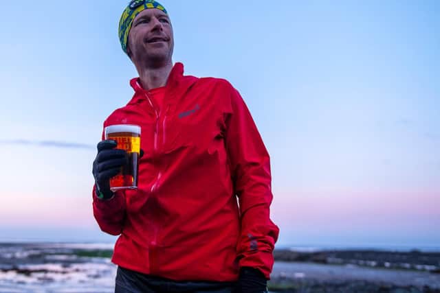 Damian Hall celebrating with a beer after completing the gruelling 185-mile challenge