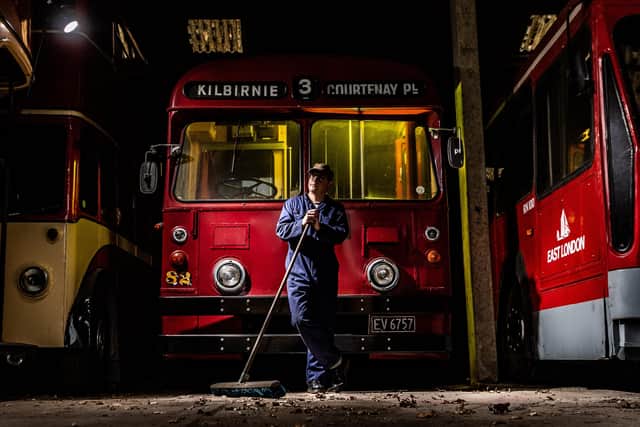 Volunteer Ian Brown, takes time out from sweeping in the holding shed and rests against a Wellington TB 82 Trolleybus from New Zealand.