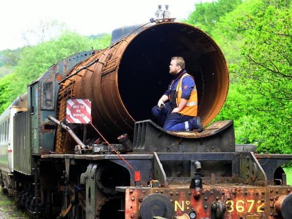 Apprentice Mark Readman checking out the boiler on the rusting Dame Vera Lynn parked up in a siding near the sheds at Grosmont on the North York Moors Railway