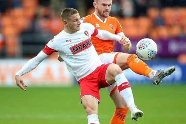Defender Ollie Turton, in background, tussles for the ball with Rotherham United's Ben Wiles in the Millers' game at Blackpool in 2019.