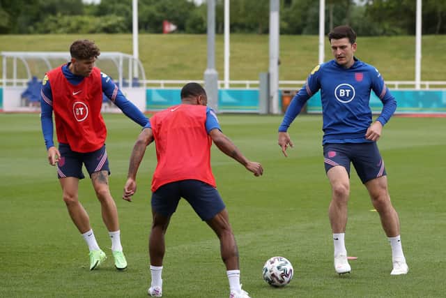 England's Harry Maguire (right) in action with John Stones (left) and Raheem Sterling during the training session at St George's Park. Picture: PA.