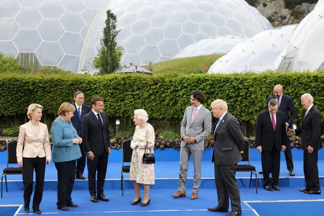 The Queen chats to President Emmanuel Macron following a photo-call with G7 leaders in Cornwall.