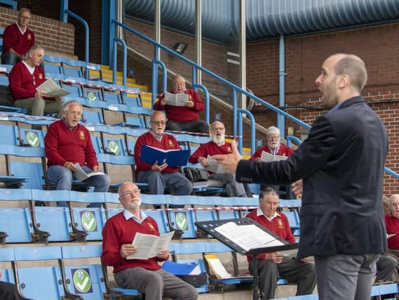 Featherstone Male Voice Choir socially distanced as they gather in the stand at a Covid secure Featherstone Rovers Rugby League Club  to practice together and not over Zoom sessions. Picture Tony Johnson