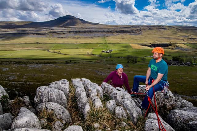 The couple climbing a rockface at Twistleton Scar, a fine area of limestone pavement that is situated on the southern lower slopes of Whernside above Ingleton in the Yorkshire Dales, with Ingleborough dominating the landscape behind. Picture: James Hardisty.