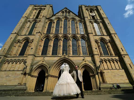 The Very Reverend John Dobson, Dean of Ripon, outside the Cathedral with a wedding dress from the new exhibition
Photo: Jonathan Gawthorpe
