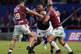 On a charge: Wakefield Trinity's David Fifita drives at Wigan Warriors' Liam Byrne and Eddie Battye.