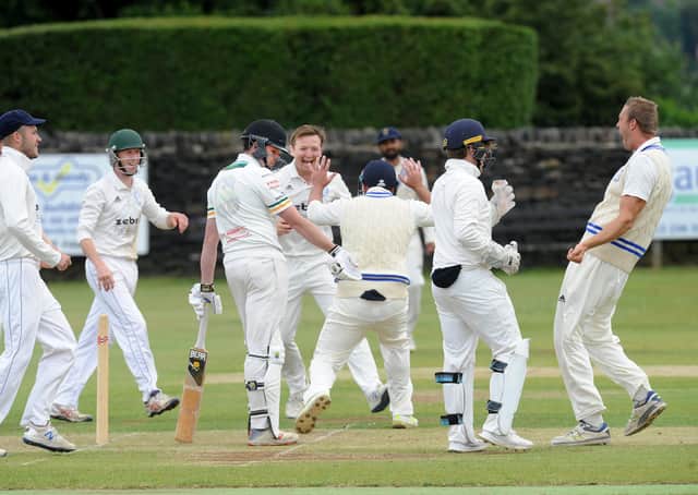 Mark Robertshaw of Pudsey St Lawrence surrounded by Farsley players after being caught by Ran Cooper for 0 off the bowling of Mathew Lumb. Picture: Steve Riding