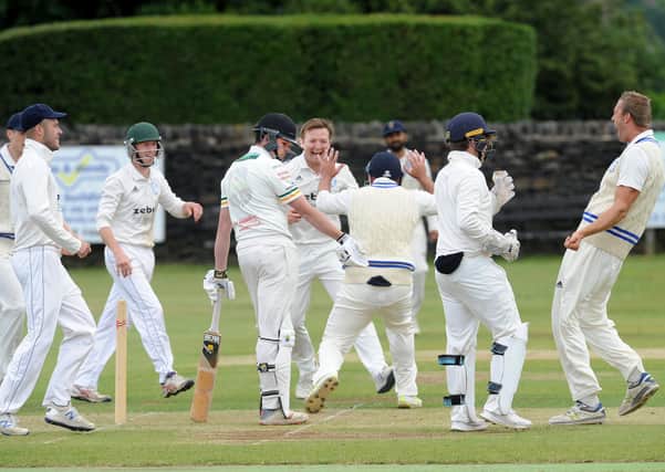 Out: Mark Robertshaw of Pudsey St Lawrence is surrounded by Farsley players after being caught by Ran Cooper for 0 off the bowling of Mathew Lumb in the Bradford League. Pictures: Steve Riding