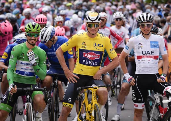 France's Julian Alaphilippe, wearing the best sprinter's green jersey, Netherland's Mathieu Van Der Poel, wearing the overall leader's yellow jersey, and Slovenia's Tadej Pogacar, wearing the best young rider's white jersey, wait for the start of the third stage of the Tour de France on Monday. (AP Photo/Daniel Cole)