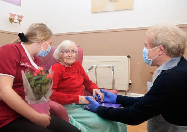 Mike Padgham (right) visits his 93-year-old mother Phyllis Padgham (centre) with Activities Assistant Charlotte Henderson (left) at St Cecilia's Nursing Home in Scarborough, North Yorkshire.