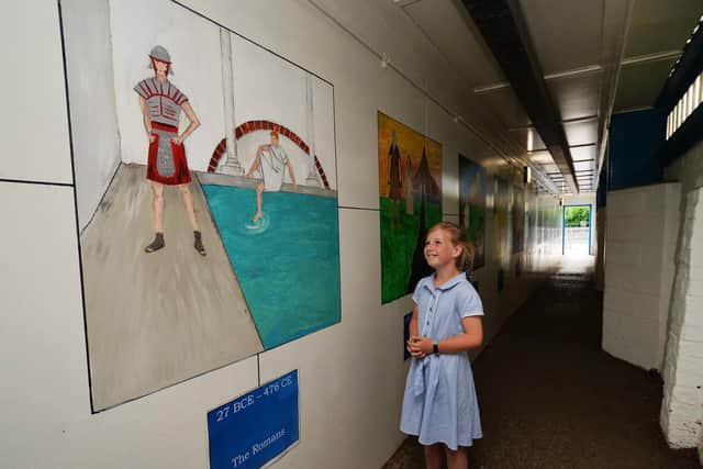Pictured Ellie May Sheilds viewing the pictorial timeline of the school's history on a tunnel which connects the school's two sites, created by school teachers under lockdown. Picture: Jonathan Gawthorpe