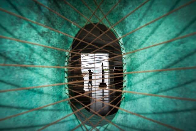 A woman is viewed through a sculpture as she photographs the Barbara Hepworth: Art and Life exhibition at the Hepworth Wakefield art museum in Wakefield. Picture: Danny Lawson/PA