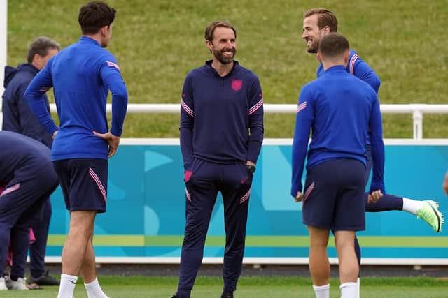 England captain Harry Kane shares a joke with manager Gareth Southgate during Friday's training session at St George's Park. Picture: Martin Rickett/PA