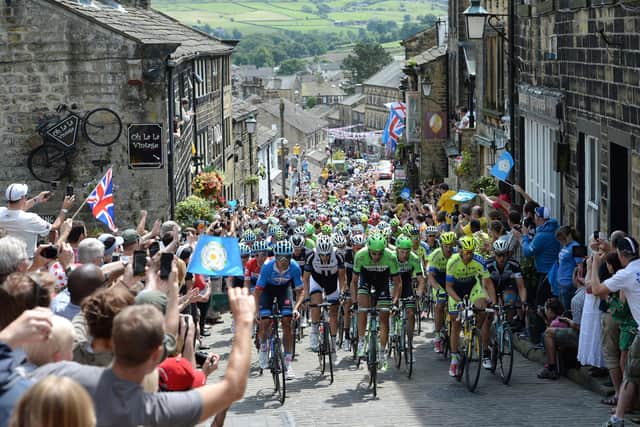 The peloton rides up Main Street as stage two of the Tour de France passes through Haworth. (Picture Martin Rickett/PA Wire)