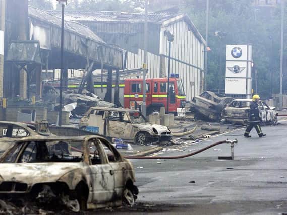 A firefighter outside a burned out BMW showroom in Bradford Sunday July 8 2001, after last night's violence in the city which was sparked by an Anti Nazi League demonstration against the National Front. Picture: PA