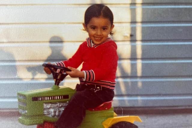 Anita Rani as a child on a toy tractor