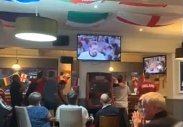Englad fans watch in trepidation as Harry Kane steps up to take the penalty...