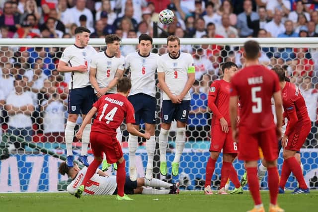 Mikkel Damsgaard of Denmark scores despite the close attention of England's wall. (Photo by Laurence Griffiths/Getty Images)