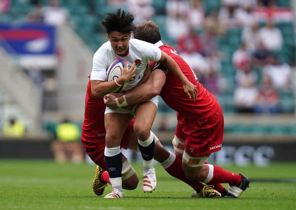 England's Marcus Smith (centre) tackled by Canada's Lucas Rumball (left) and Reegan O'Gorman during the Summer Series match at Twickenham Stadium, London. Picture date: Saturday July 10, 2021. PA Photo.Harlequins and England fly-half Marcus Smith has been called up by the British and Irish Lions as injury cover for Finn Russell, the Lions have announced. See PA story RUGBYU Lions. Photo credit should read: Andrew Matthews/PA Wire. 
RESTRICTIONS: Use subject to restrictions. Editorial use only, no commercial use without prior consent from rights holder.