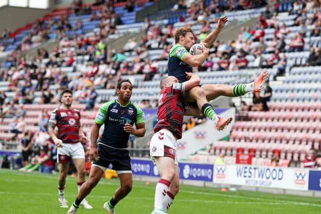 Huddersfield Giants' Olly Ashall-Bott is caught high in the air by Wigan's Liam Marshall. (PAUL CURRIE/SWPIX)