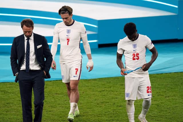England manager Gareth Southgate stands dejected alongside Bukayo Saka and Jack Grealish following the UEFA Euro 2020 Final at Wembley