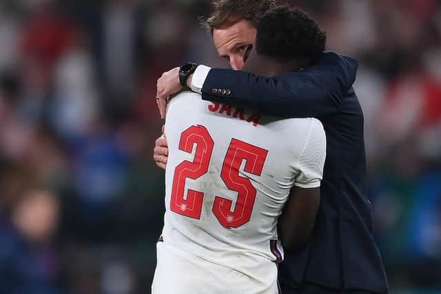 England's coach Gareth Southgate speaks to England's midfielder Bukayo Saka after their loss in the UEFA EURO 2020 final football match between Italy and England at the Wembley Stadium in London on July 11, 2021. (Photo by Laurence Griffiths / POOL / AFP)