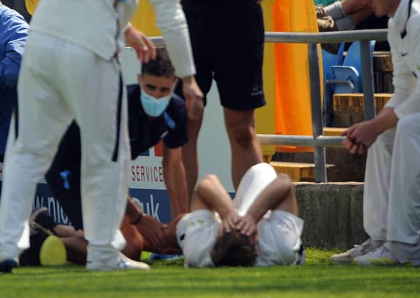 Yorkshire pace bowler Dominic Leech receives treatment on the Headingley pitch after njuring his knee during the Roses match. Picture: Steve Riding