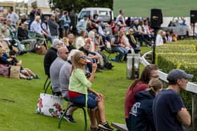 Visitors to the first day of the show relax in the fine weather to watch the showjumping in the main ring. . Picture Tony Johnson