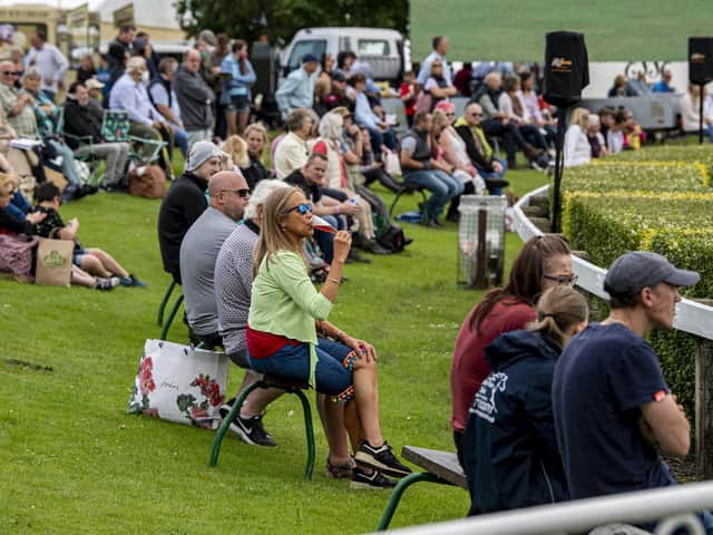 Visitors to the first day of the show relax in the fine weather to watch the showjumping in the main ring. . Picture Tony Johnson