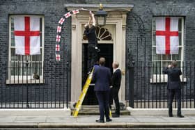 England flag bunting decorations are removed from outside 10 Downing Street after Italy beat England to win Euro 2020