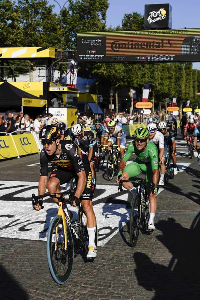 Belgium's Wout Van Aert crosses the finish line to win ahead of Britain's Mark Cavendish, wearing the best sprinter's green jersey, right, on the Champs Elysees in Paris. Picture: AP/Daniel Cole.