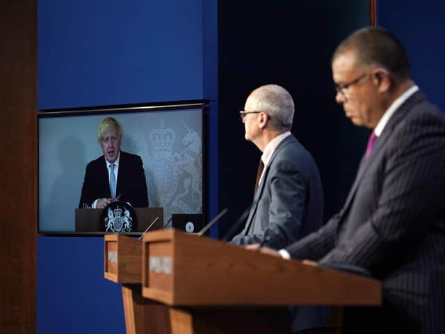 Prime Minister Boris Johnson appears on a screen from Chequers, the country house of the serving UK Prime Minister, where he is self-isolating, chief scientific adviser Sir Patrick Vallance and deputy chief medical officer for England Professor Jonathan Van Tam (Alberto Pezzali/PA)