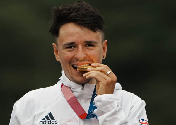 Gold chunk: Tom Pidcock  bites his medal on the podium.