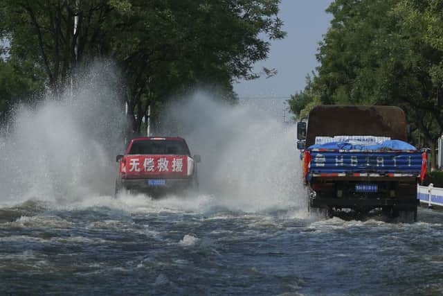 A truck with a banner which reads "Free Assistance" drives through floodwaters in Xinxiang in central China's Henan province on Sunday, July 25, 2021. Trucks carrying water and food on Sunday streamed into the Chinese city at the center of flooding that killed dozens of people, while soldiers laid sandbags to fill gaps in river dikes that left neighborhoods under water.
