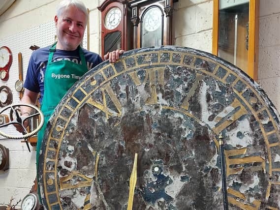 Horologist Andrew Bates with the clock