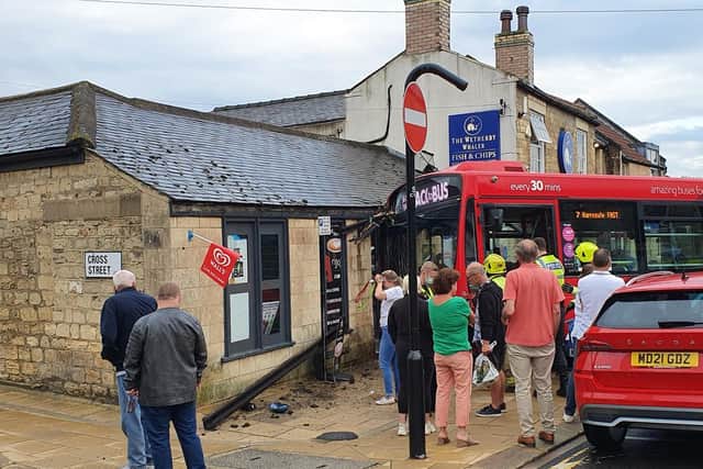 Crowds gather after bus has hit the shop front of Youngs of Wetherby with fire crews currently at the scene assessing the damage. Photo credit: Submitted photo