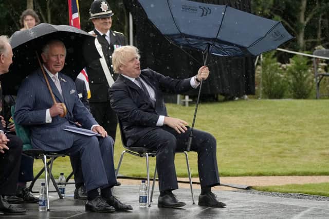The Prince of Wales looks on as Prime Minister Boris Johnson opens an umbrella at the unveiling of the UK Police Memorial at the National Memorial Arboretum at Alrewas, Staffordshire.